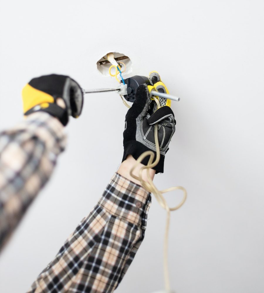 electrician fixes electrical wiring of lamp